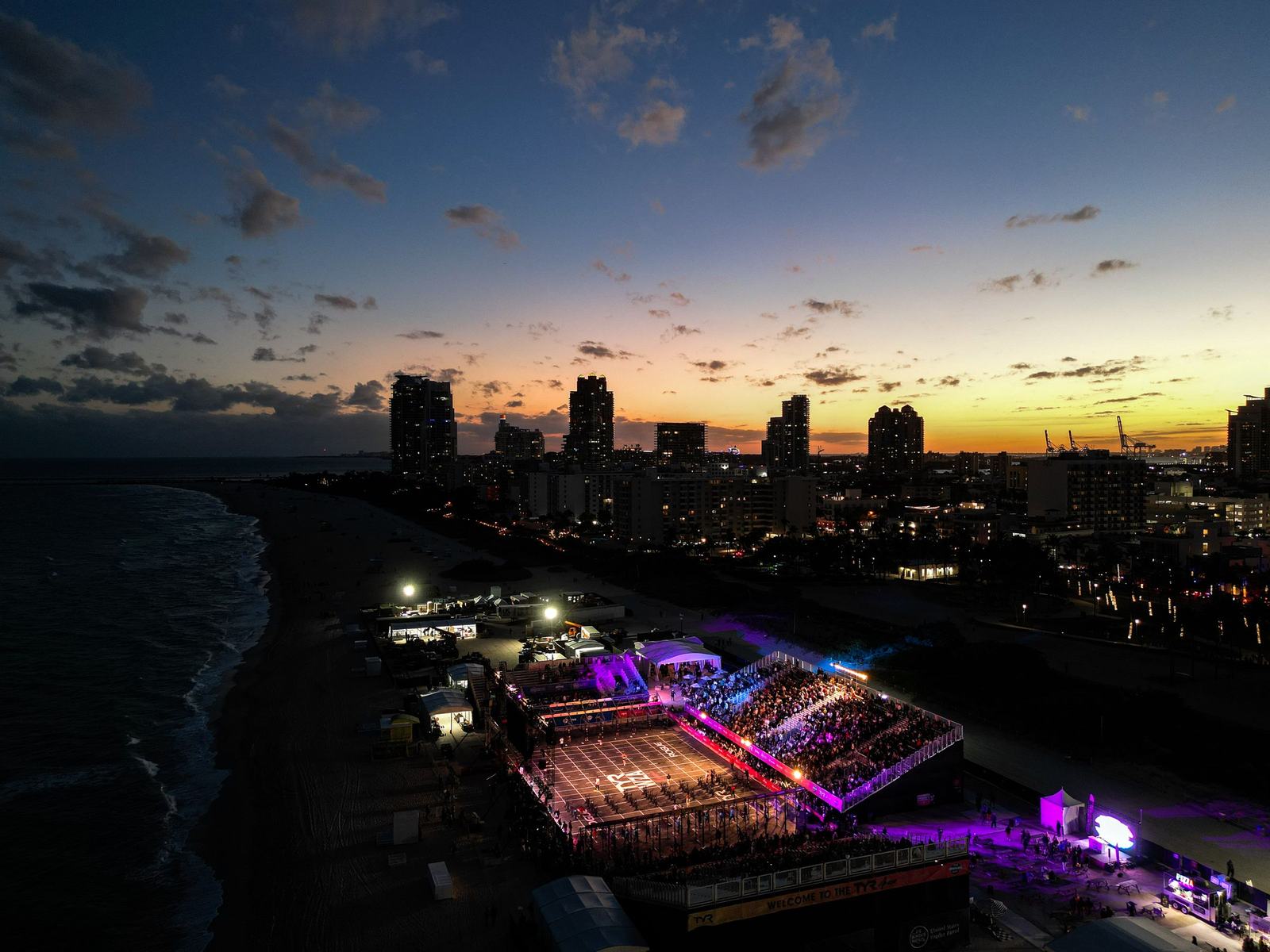 The arena glowing purple at dusk with the Miami Beach skyline behind