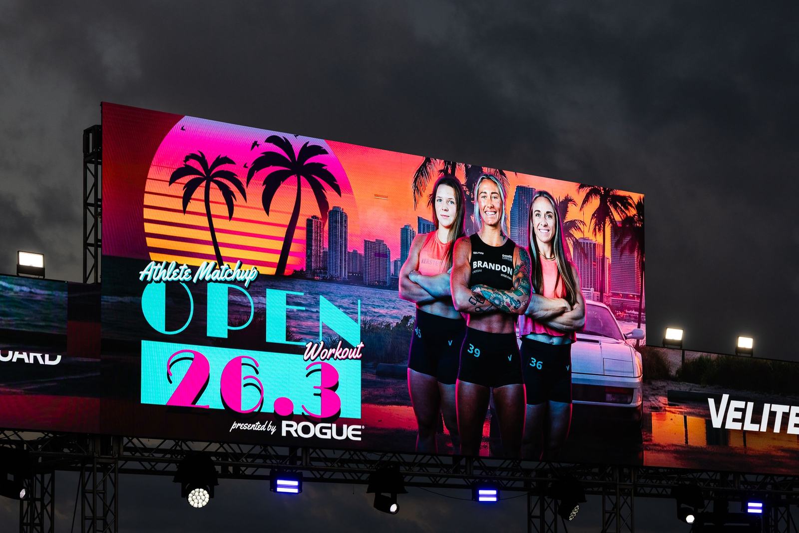 A giant LED screen on a lit stage rig at night